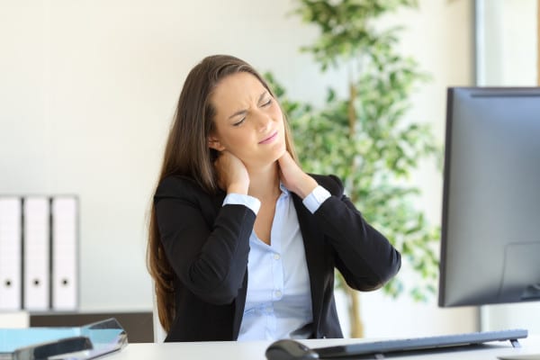 A woman in the office having a neck pain