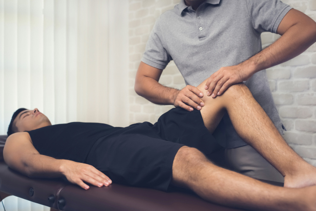 An athlete having a sports massage on his knee